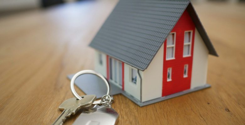 white and red wooden house miniature on brown table